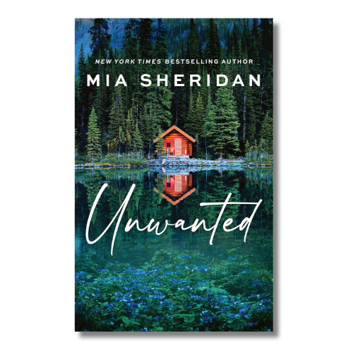 Book cover for 'Unwanted' by Mia Sheridan, featuring a small red cabin reflected in a dark blue lake surrounded by pine trees, with white script title text.